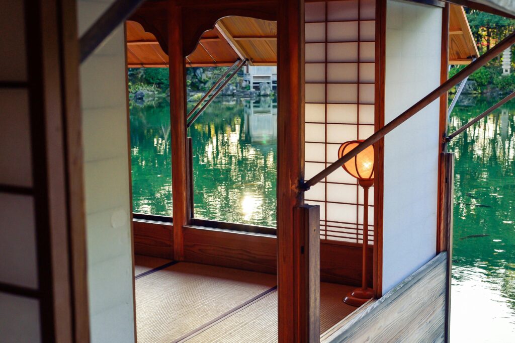 Serene Japanese-style room with shoji screens and a lake view at sunset.